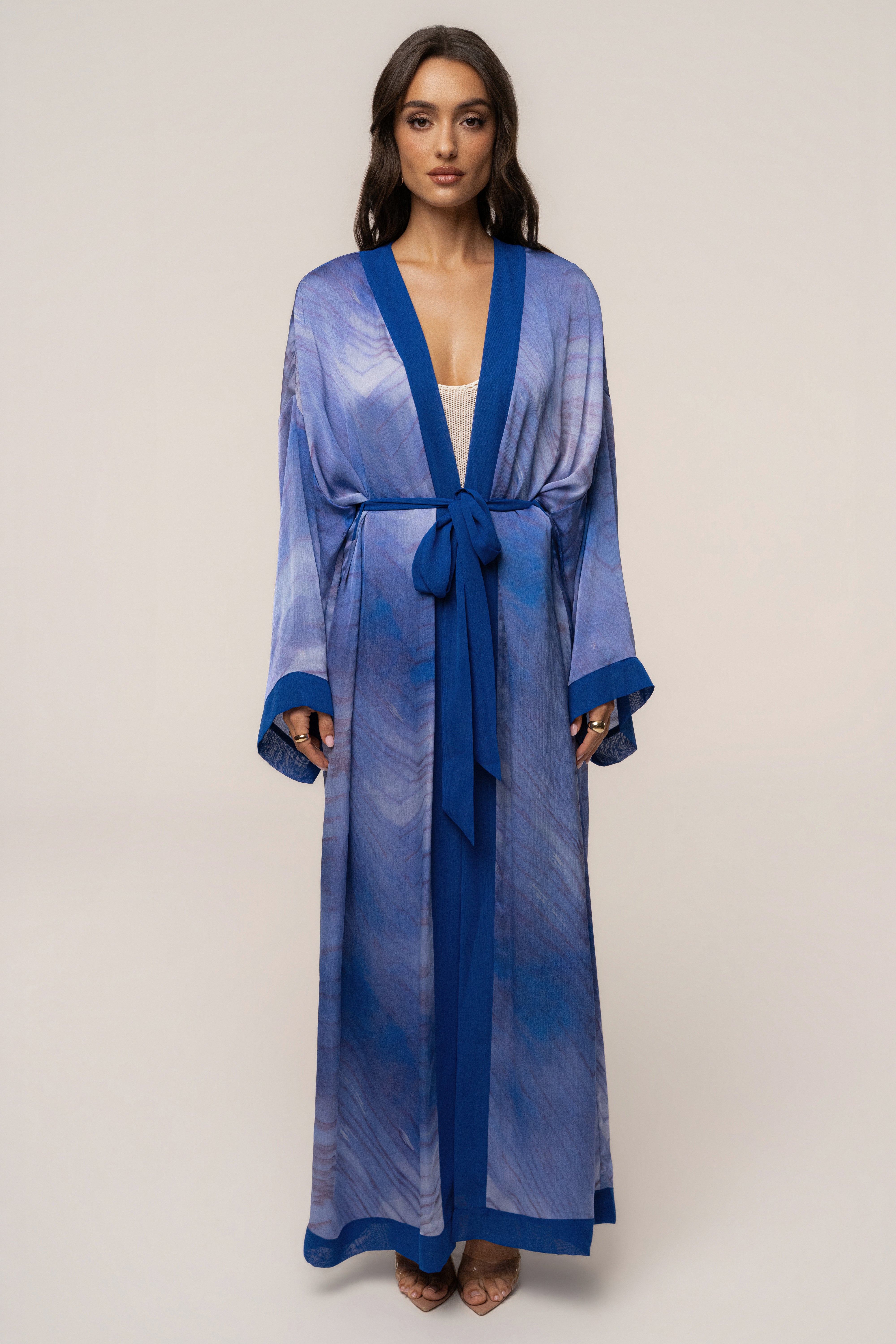 Blue Bahía satin duster outerwear by JLUXLABEL, shown hanging with a smooth, shiny satin fabric and long sleeves.