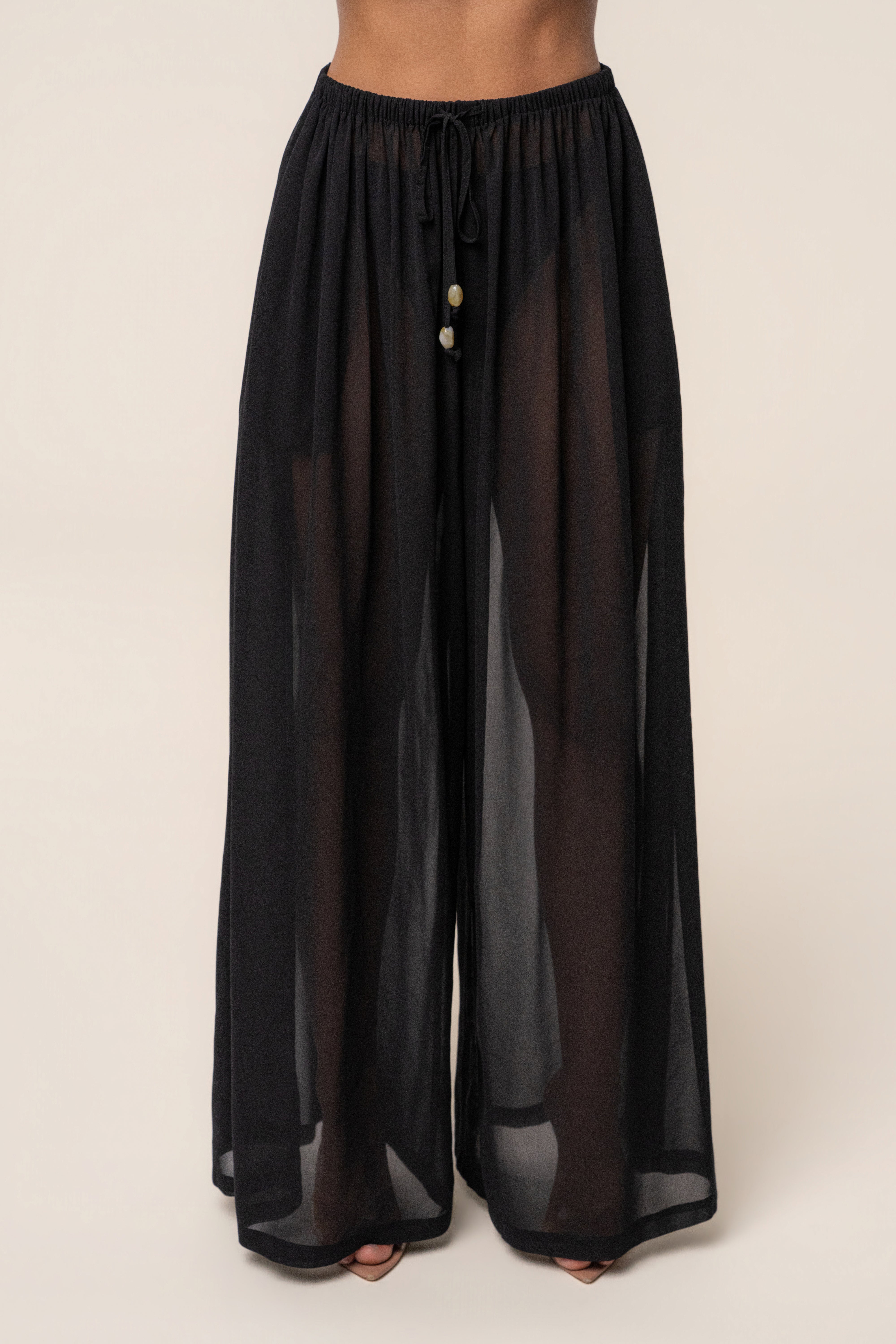 Black Resort Glow chiffon pants by JLUXLABEL, featuring flowy fabric and relaxed fit, perfect for casual or vacation wear.