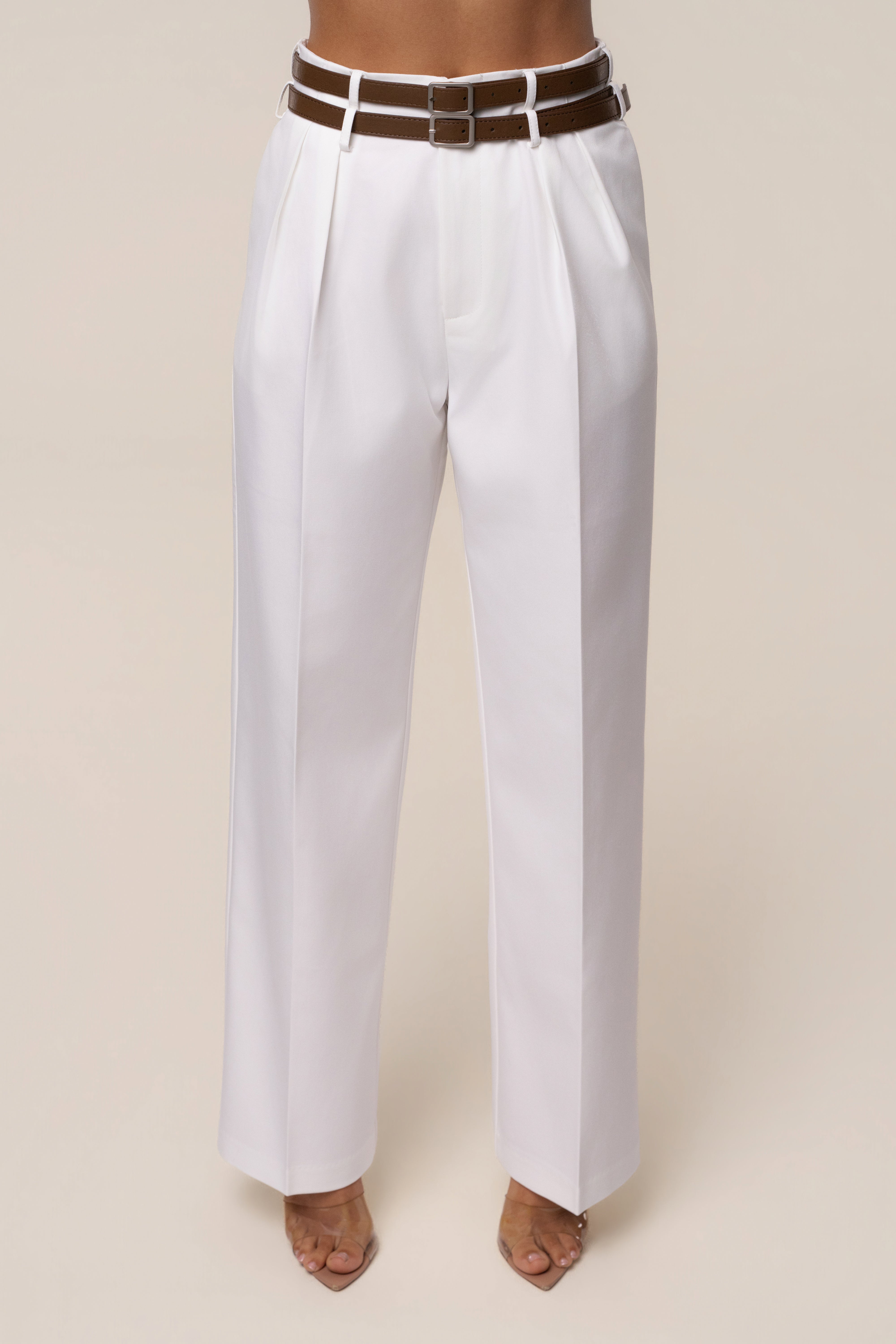 Ivory modern belted trousers by JLUXLABEL featuring a tailored fit and sleek design, shown on a model.