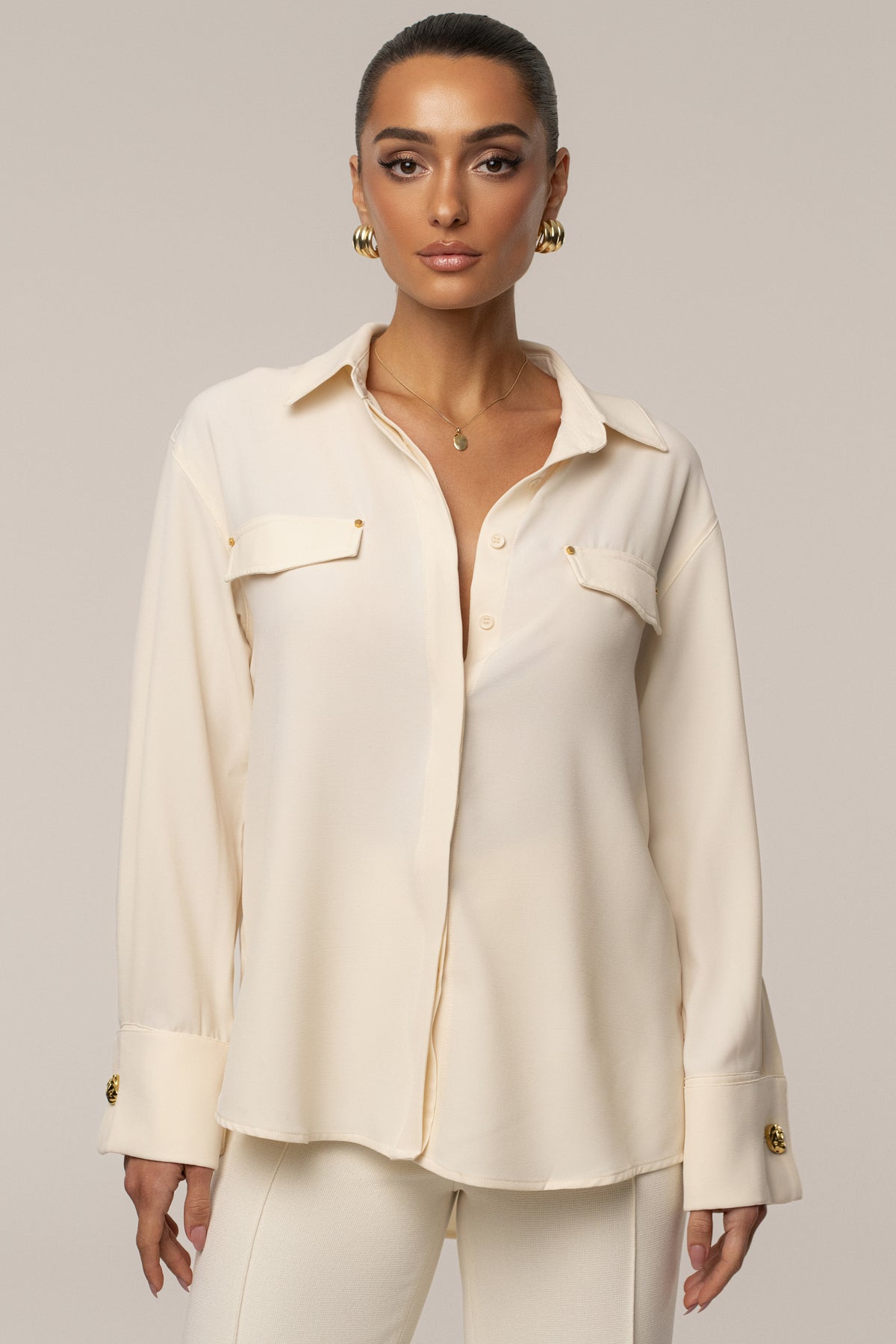 JLUXLABEL Buttercream Stella button-up shirt, light-colored tops with a classic collar and button closure, styled on a model.