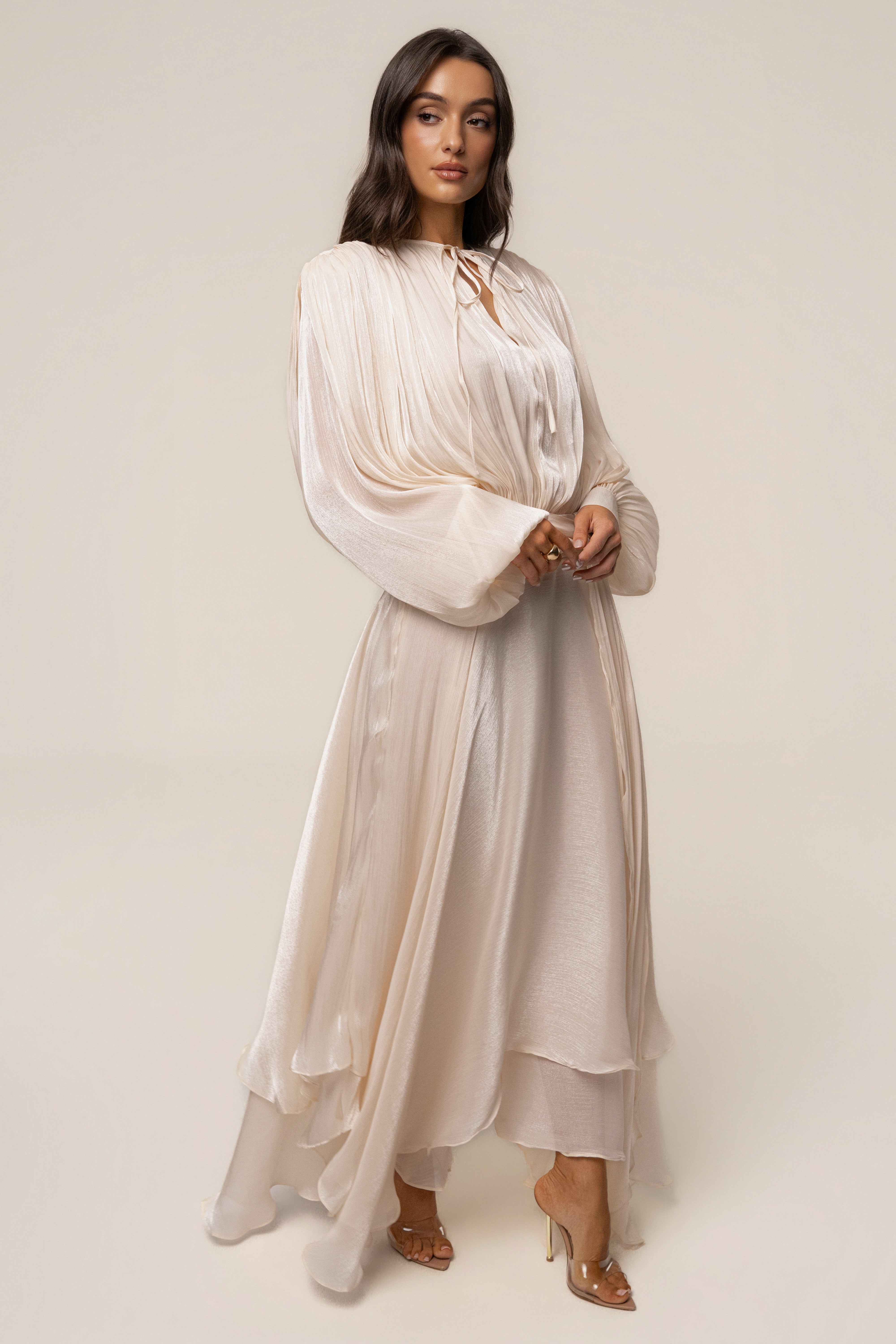 Cream draped maxi dress by JLUXLABEL featuring elegant flowing fabric and a sophisticated silhouette.