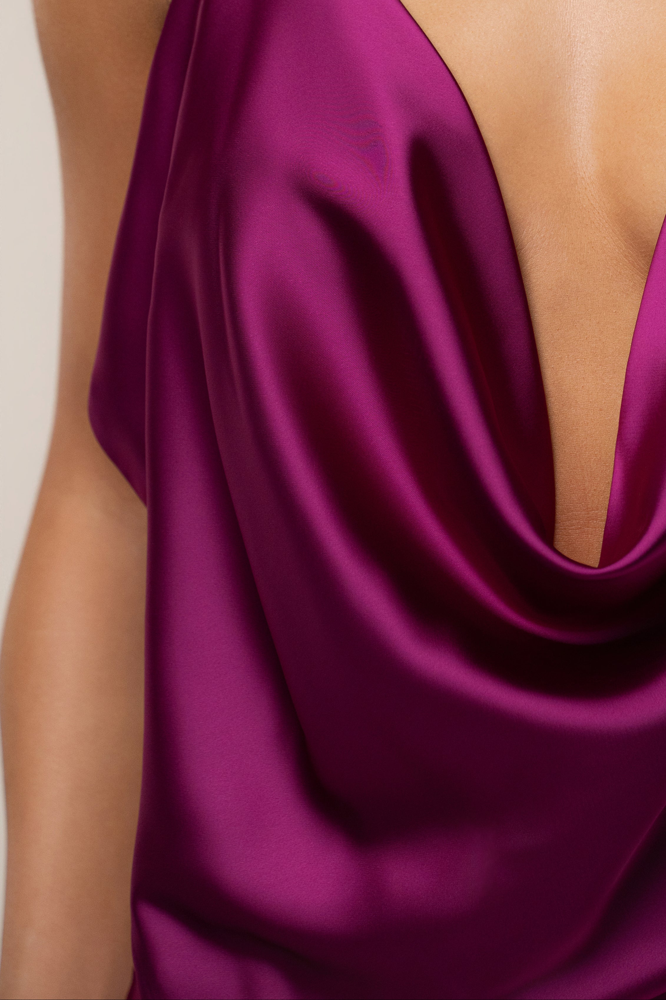Close up of a model wearing a fuchsia Delmara Cowl Maxi Dress with a deep V neckline and layered gold necklaces