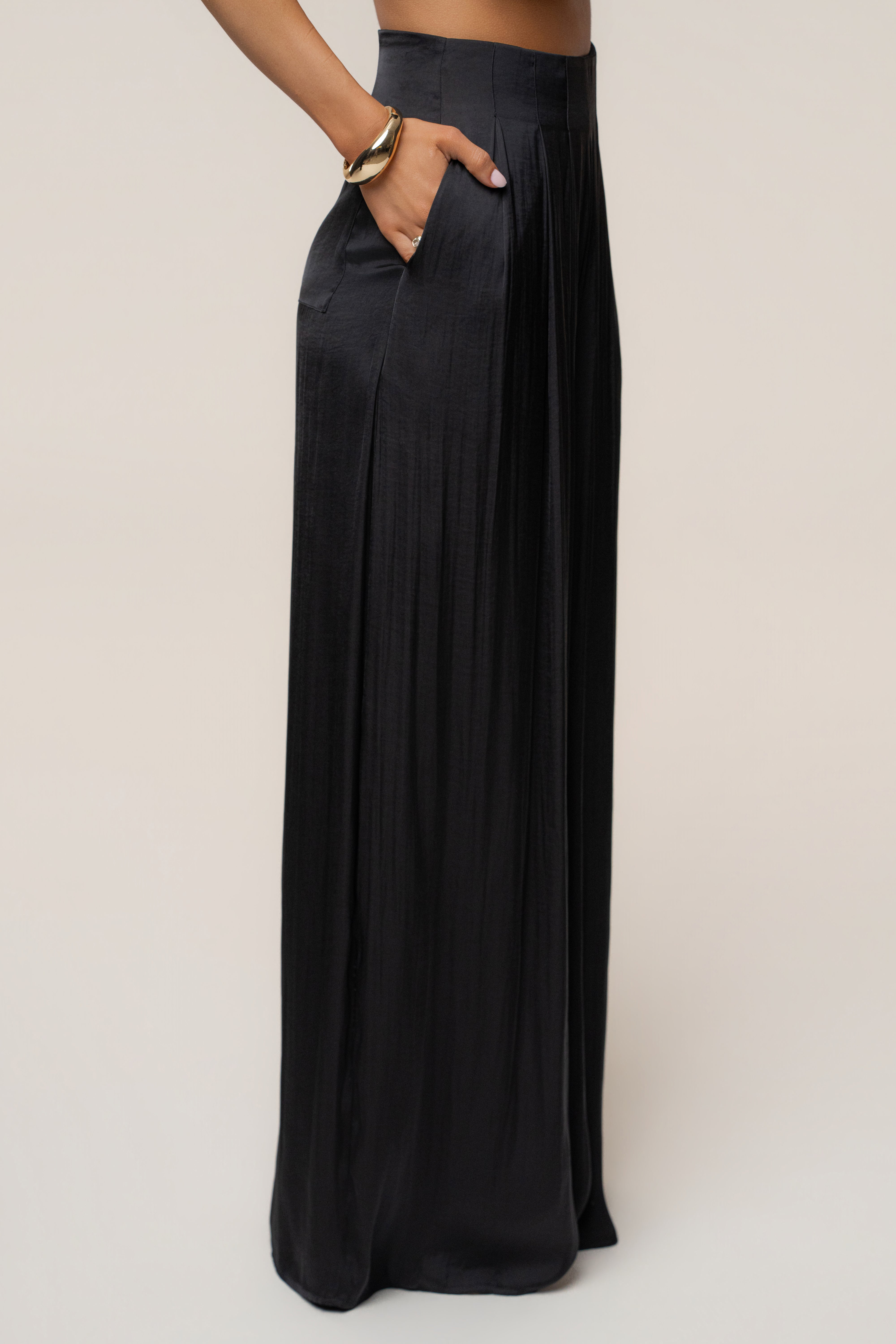 Side view of black Core Form pleated trousers with a pocket