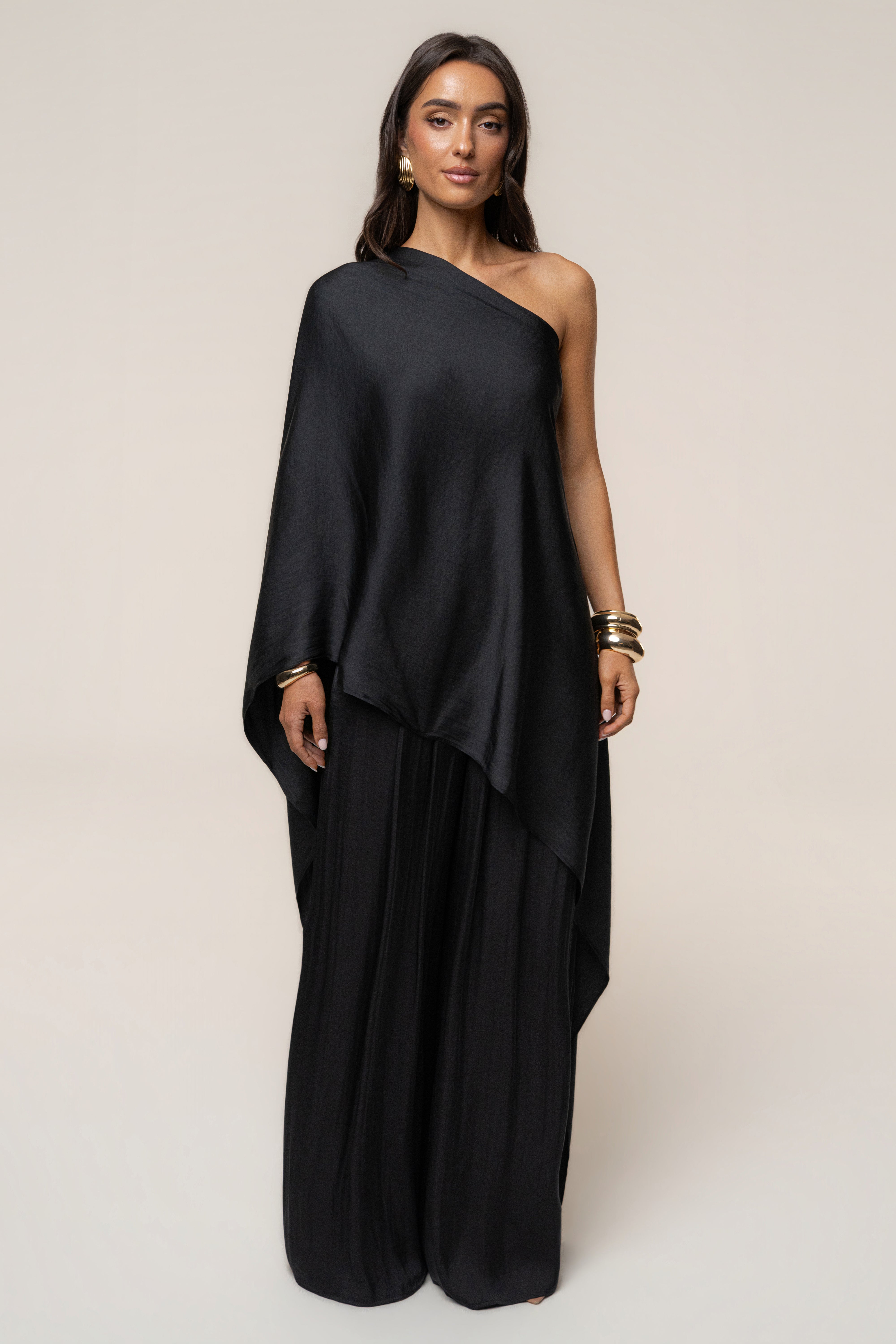 Front view of a model in a black strapless wrap dress with the Black Marina Multi-Wrap Scarf draped over one shoulder