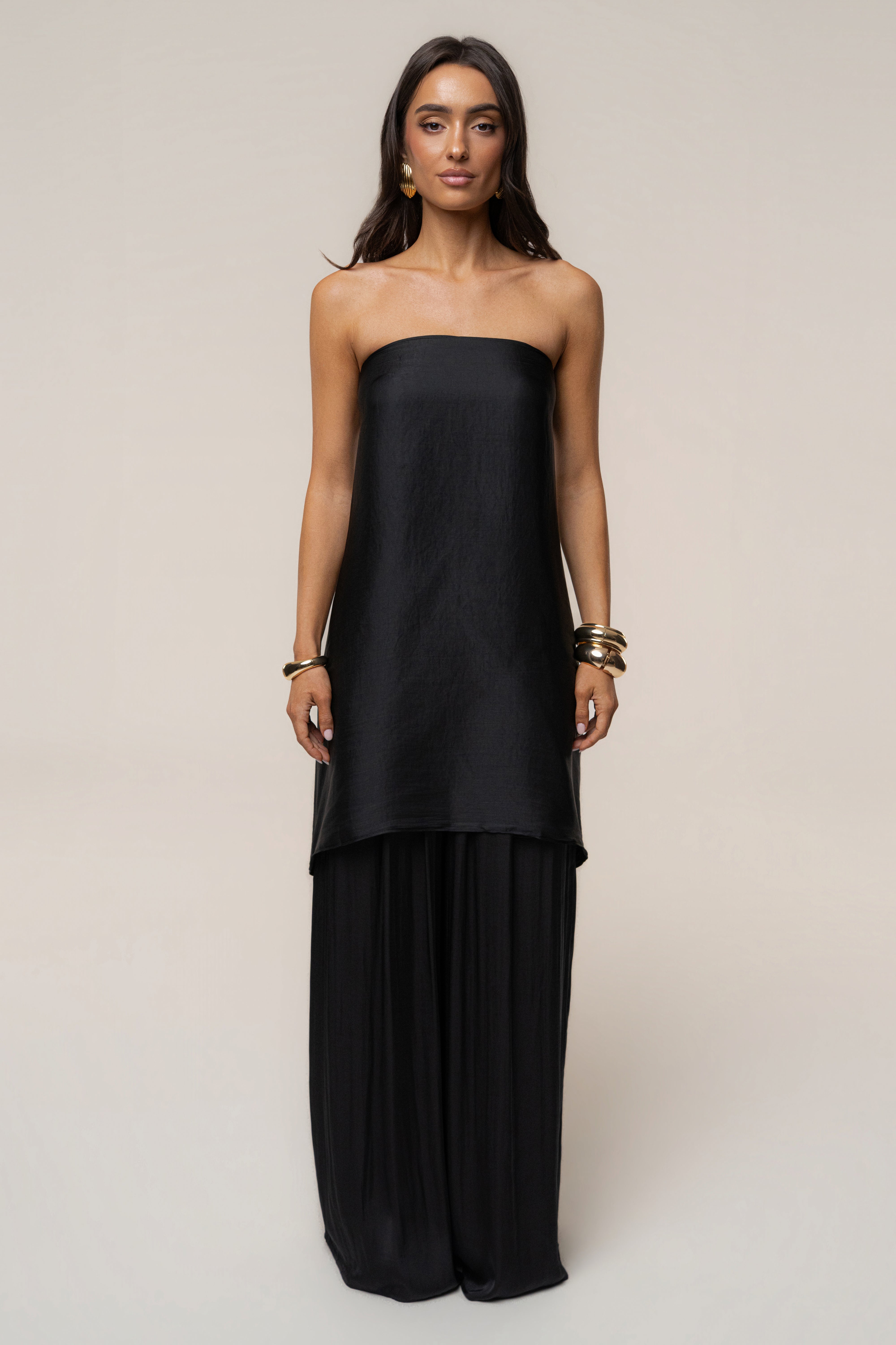 Full body shot of a model wearing a black wrap dress with the Black Marina Multi-Wrap Scarf styled as a draped top over the shoulders