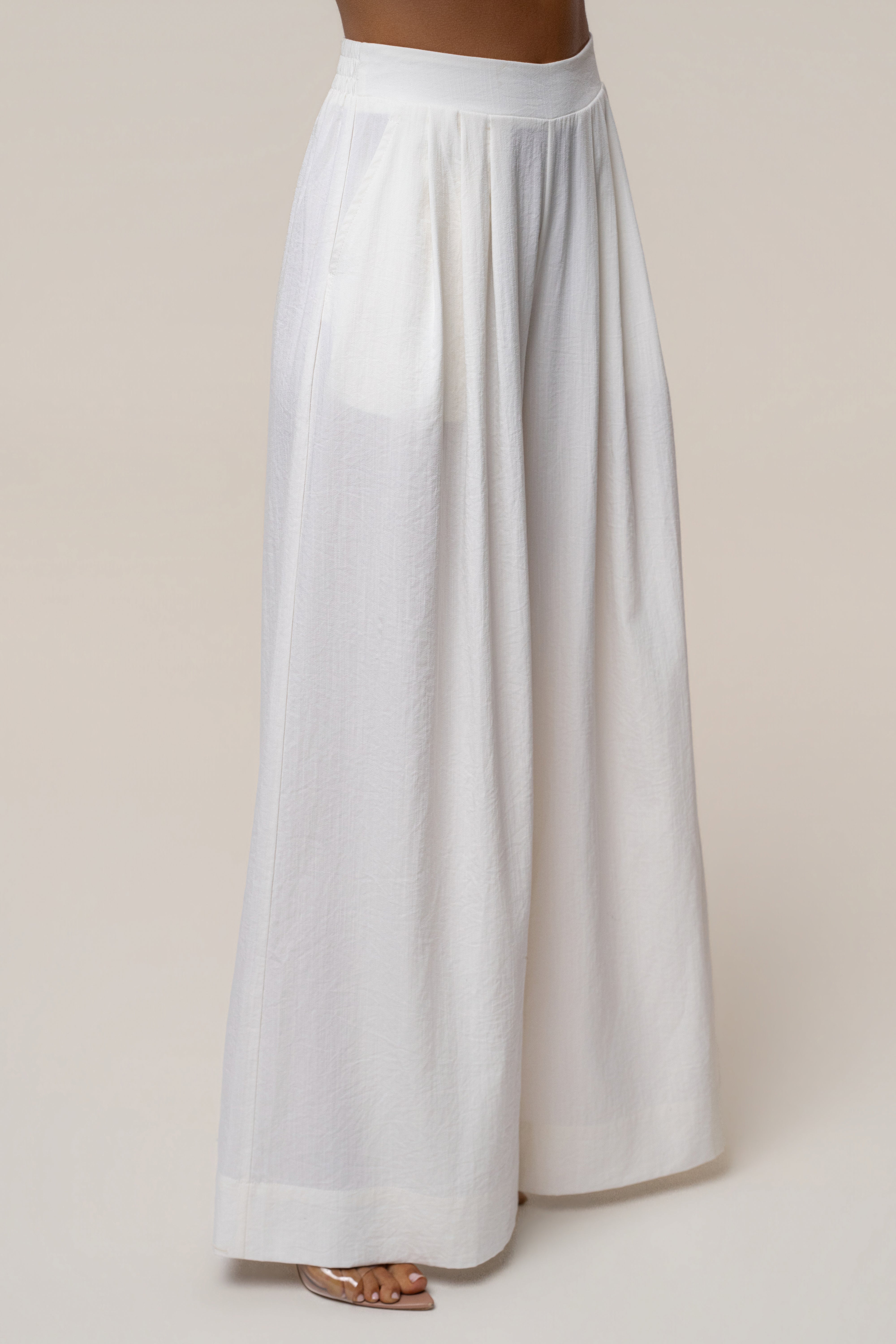 Side view of model in ivory Sunset Breeze pant set showing high waistband and flowing wide-leg pants.