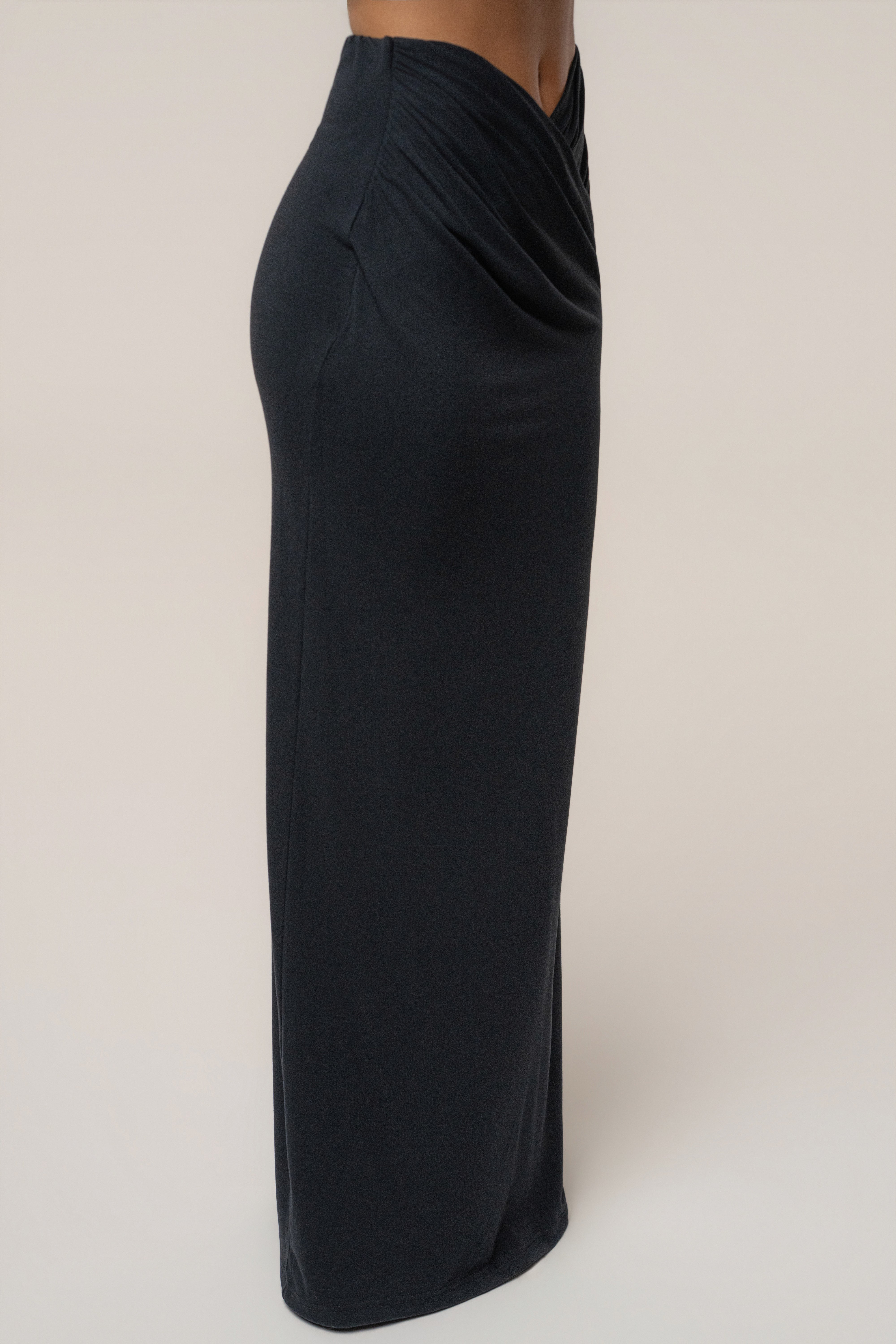 Side view of Black Passion Maxi Skirt fitted at the hips with a draped waist