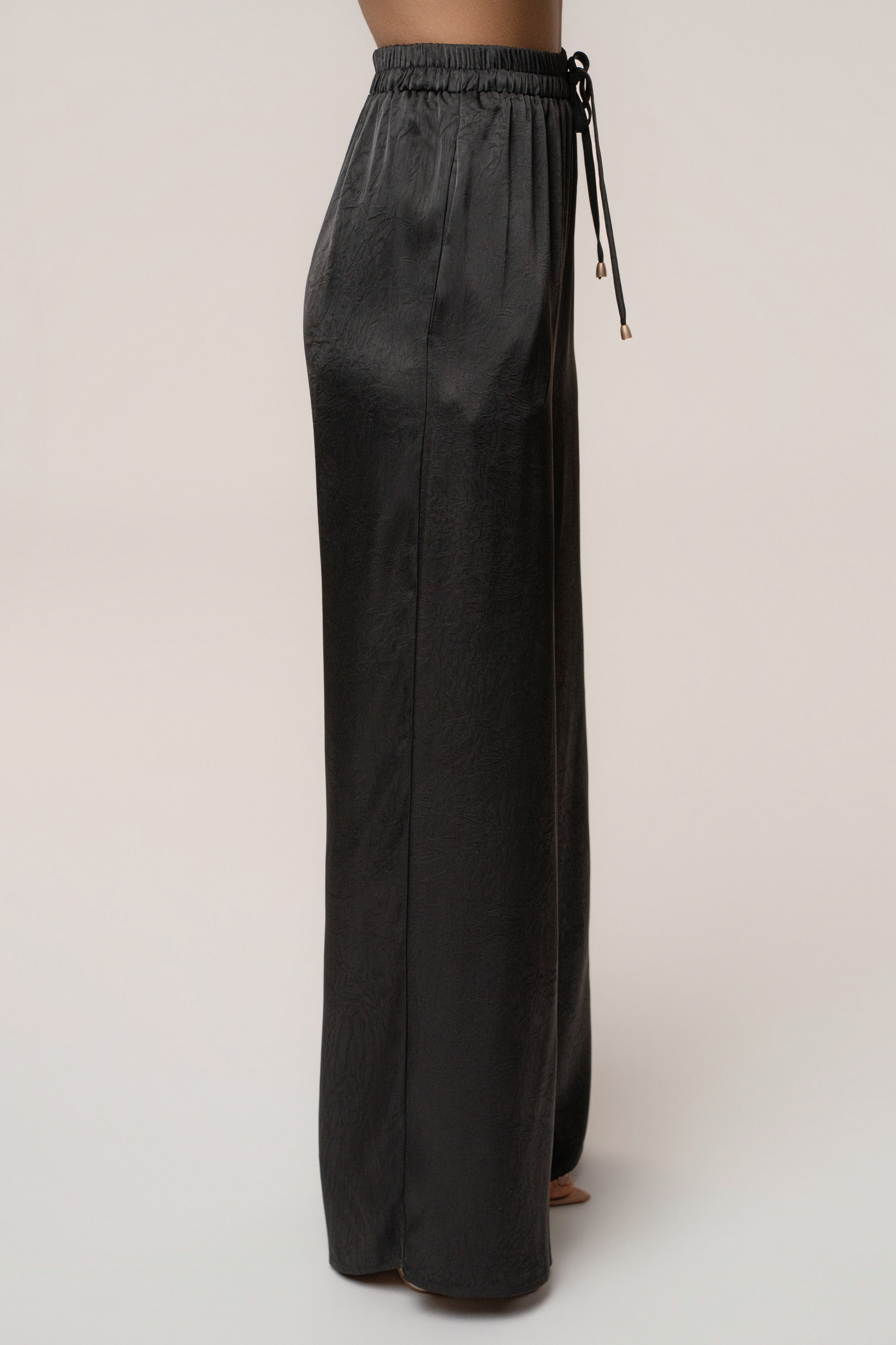 Black satin pant set with draped design from JLUXLABEL, featuring a stylish matching top and wide-leg pants.