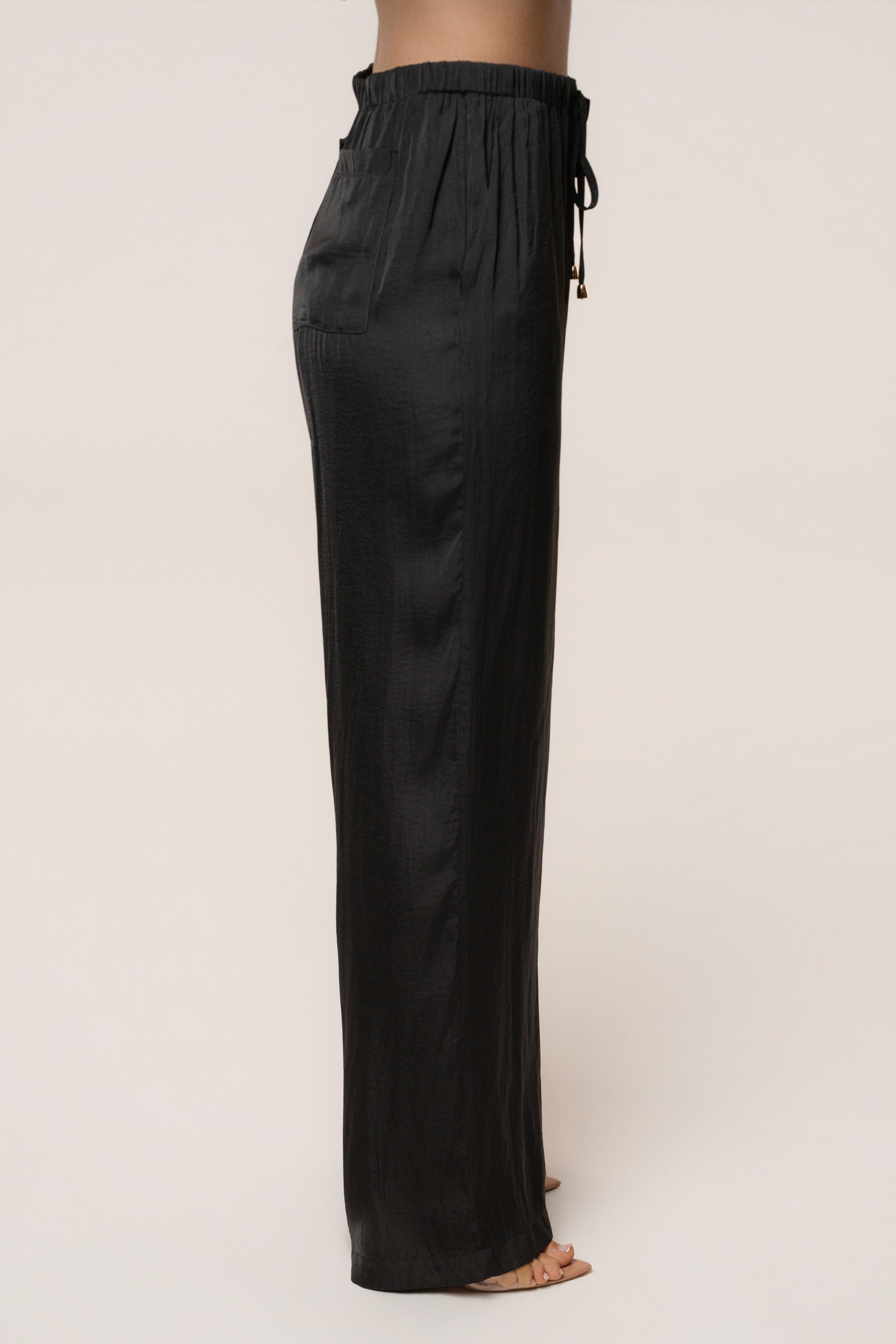 Black Seaside Glow Pants from JLUXLABEL, stylish bottoms with a relaxed fit and subtle glow detail, perfect for casual wear.