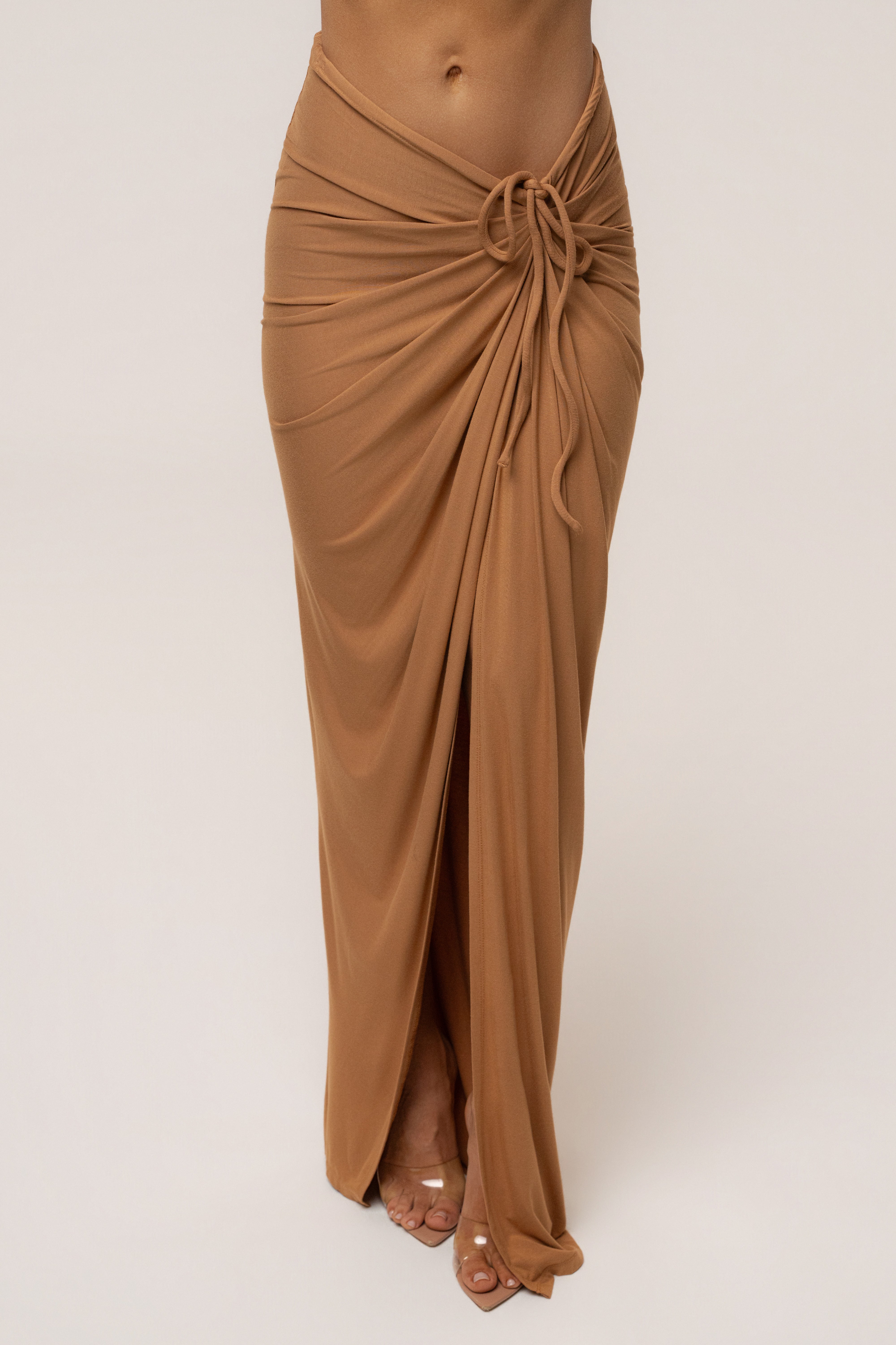Tan JLUXLABEL Island Drape Maxi Skirt shown flowing with a high waist and draped design, perfect for casual or dressy summer outfits.