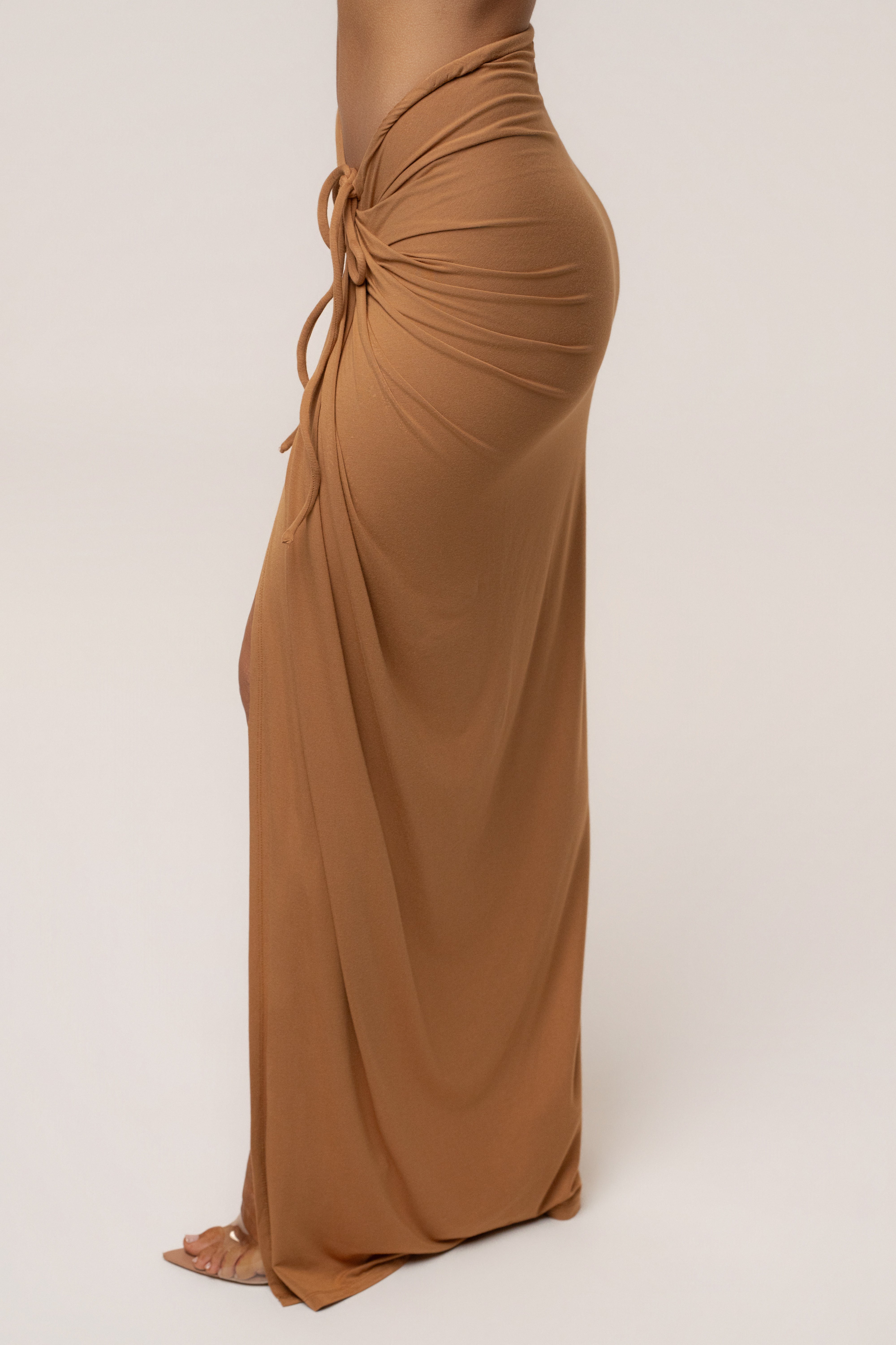 Tan JLUXLABEL Island Drape Maxi Skirt with flowing fabric and draped design, styled as a stylish bottom wear piece.