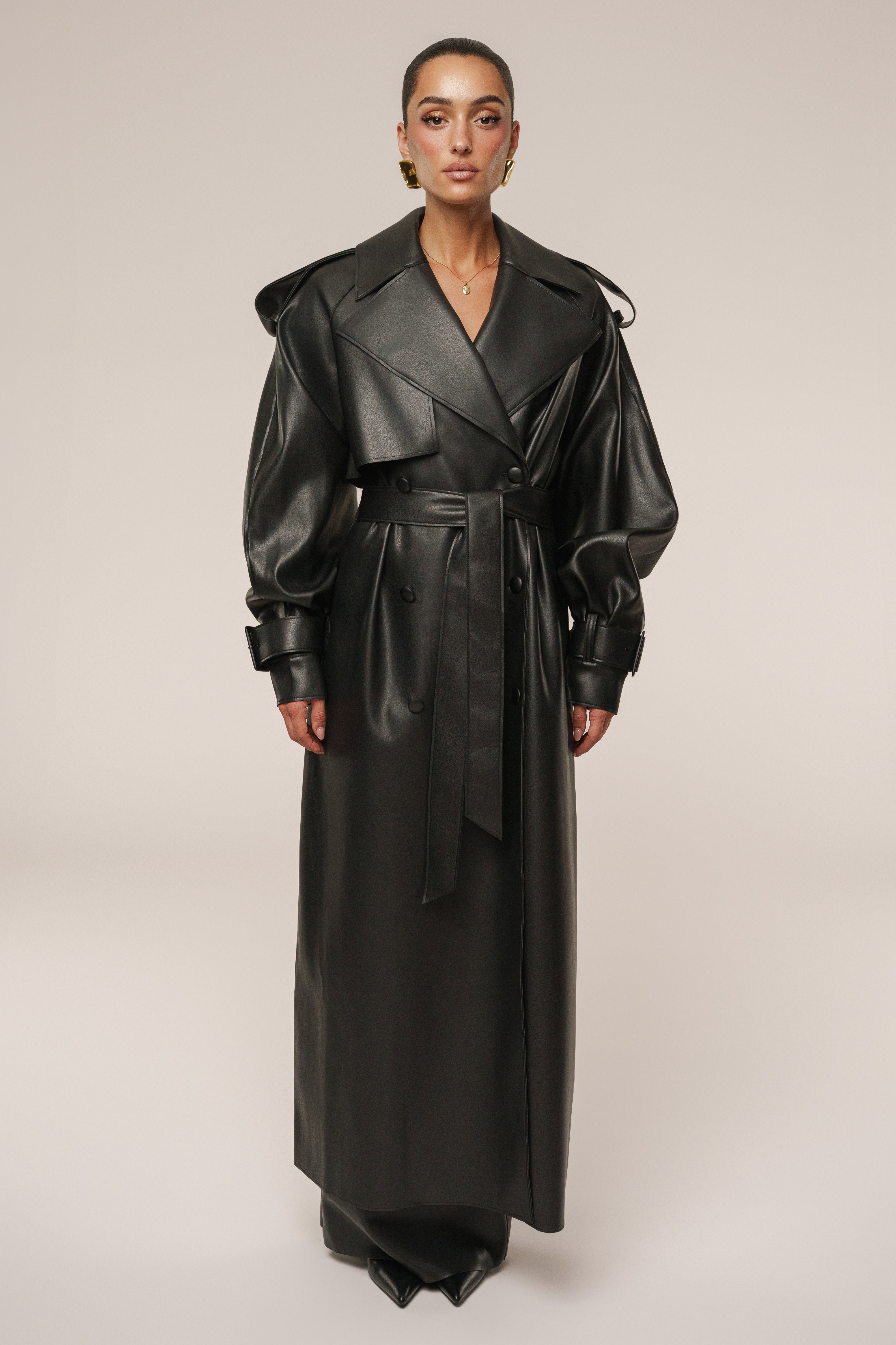 Black JLUXLABEL The Icon PU leather coat, stylish outerwear with a sleek design and button details, shown on a model.