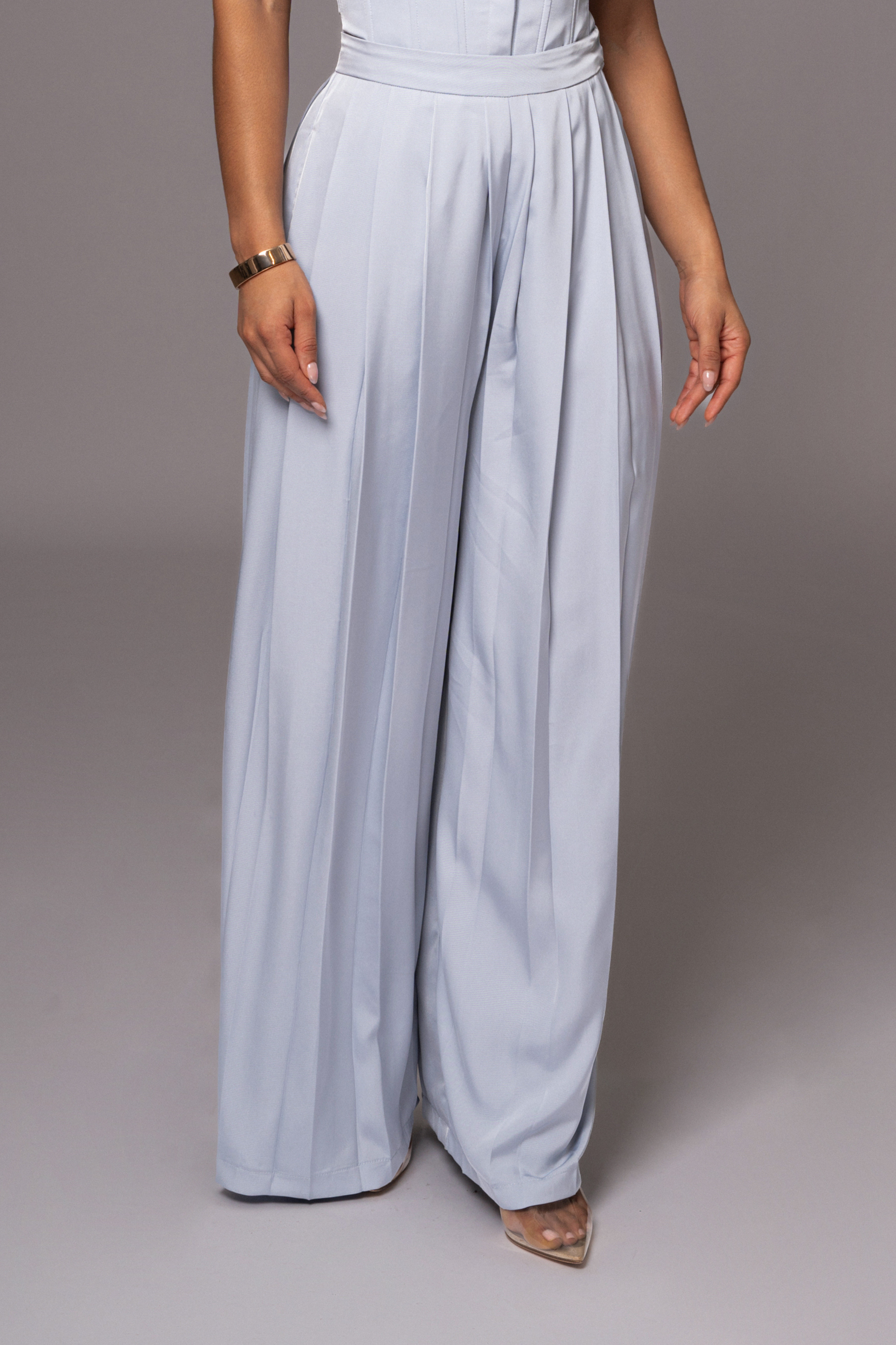 Blue Clara wide-leg pleated trousers from JLUXLABEL, showcasing their flowy fabric, high waist, and stylish pleats.